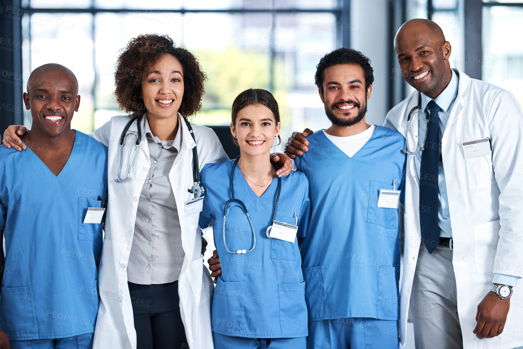 Buy stock photo Portrait, group and doctors with embrace, hospital and collaboration with interns, smile and healthcare. Team, men and women in uniform, medical professional and together to help, happy and clinic