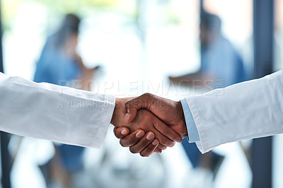 Buy stock photo Closeup shot of two unrecognizable doctors shaking hands in a hospital
