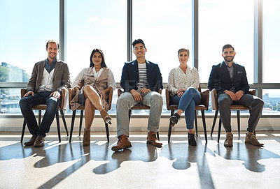 Buy stock photo Portrait of a group of businesspeople sitting in line in an office