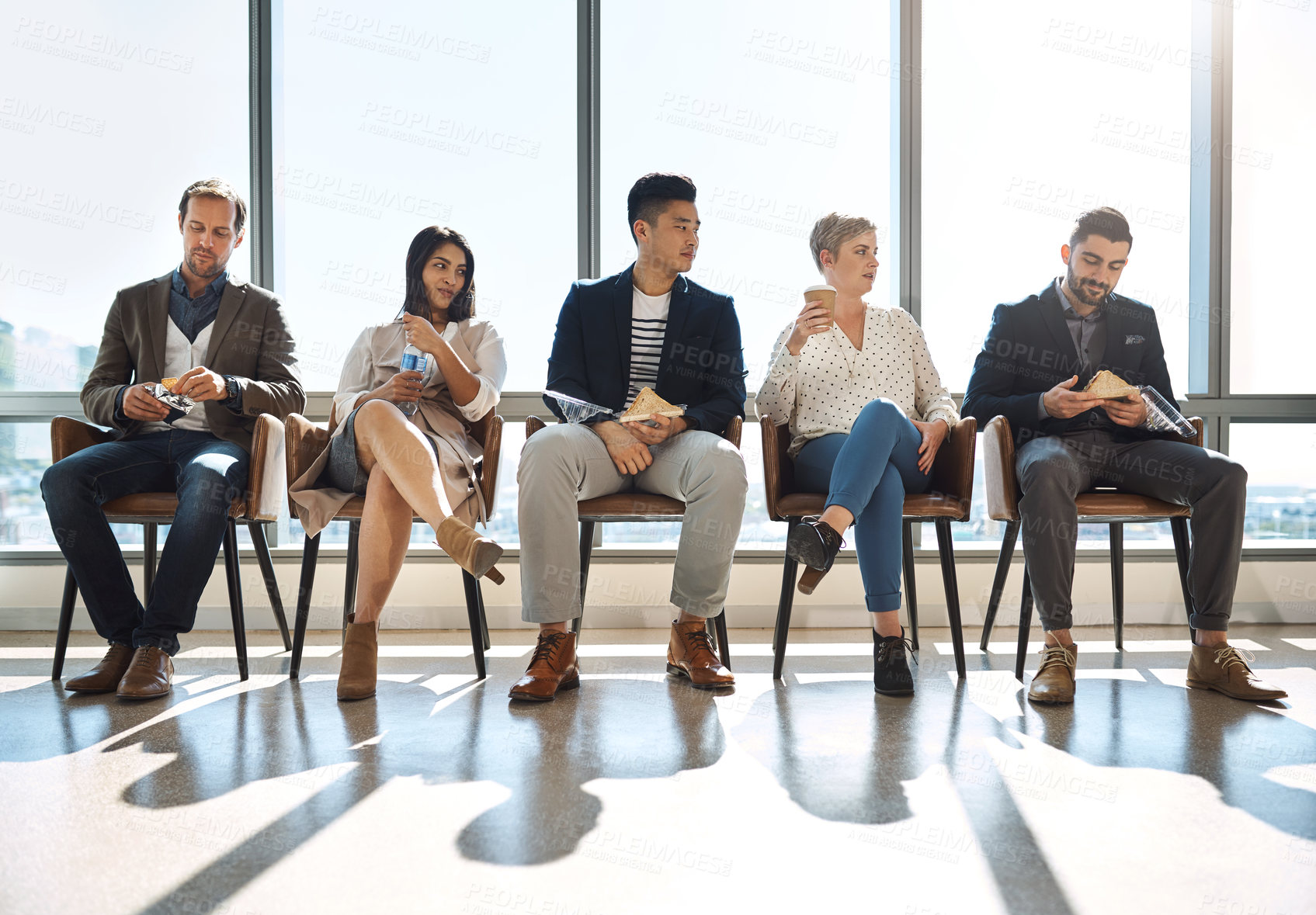 Buy stock photo Shot of a group of businesspeople taking a break while sitting in line in an office