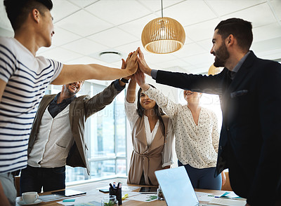 Buy stock photo Shot of a diverse group of businesspeople giving each other a high five in an office