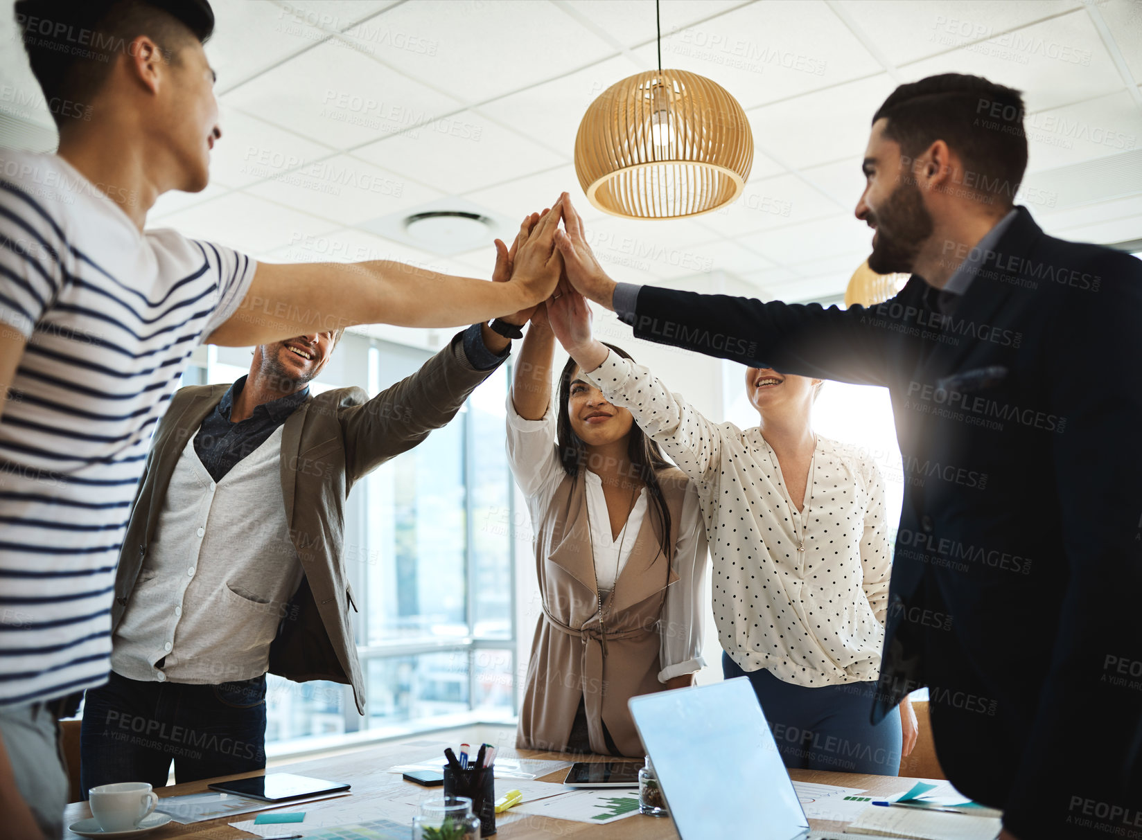 Buy stock photo Shot of a diverse group of businesspeople giving each other a high five in an office