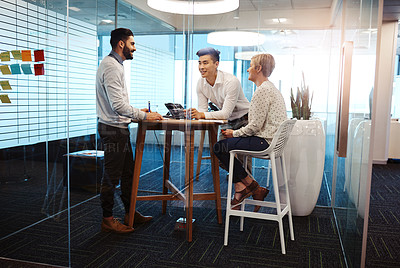 Buy stock photo Full length shot of three young businesspeople having a meeting in their office