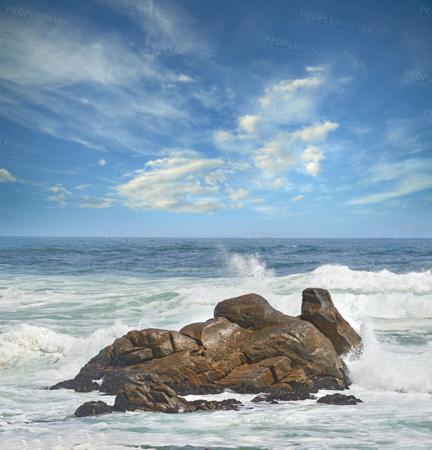Buy stock photo Copy space of a turbulent sea with rough tides and choppy waves from strong winds crashing onto big boulders at the beach with a cloudy blue sky background. Rocky coast in Western Cape, South Africa
