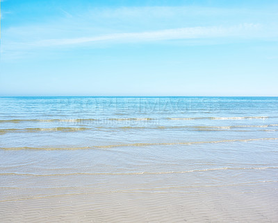 Buy stock photo Copy space at the beach with a blue sky background above the horizon. Calm ocean waves across an empty sea along the sandy shore. Peaceful and tranquil landscape for a relaxing and zen summer holiday