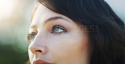 Buy stock photo Closeup shot of an attractive young woman looking away in a public park