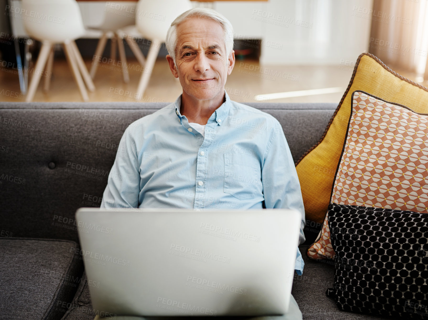 Buy stock photo Shot of a senior man relaxing and using a laptop on the sofa at home
