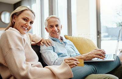 Buy stock photo Shot of a mature couple using a credit card and laptop on the sofa at home