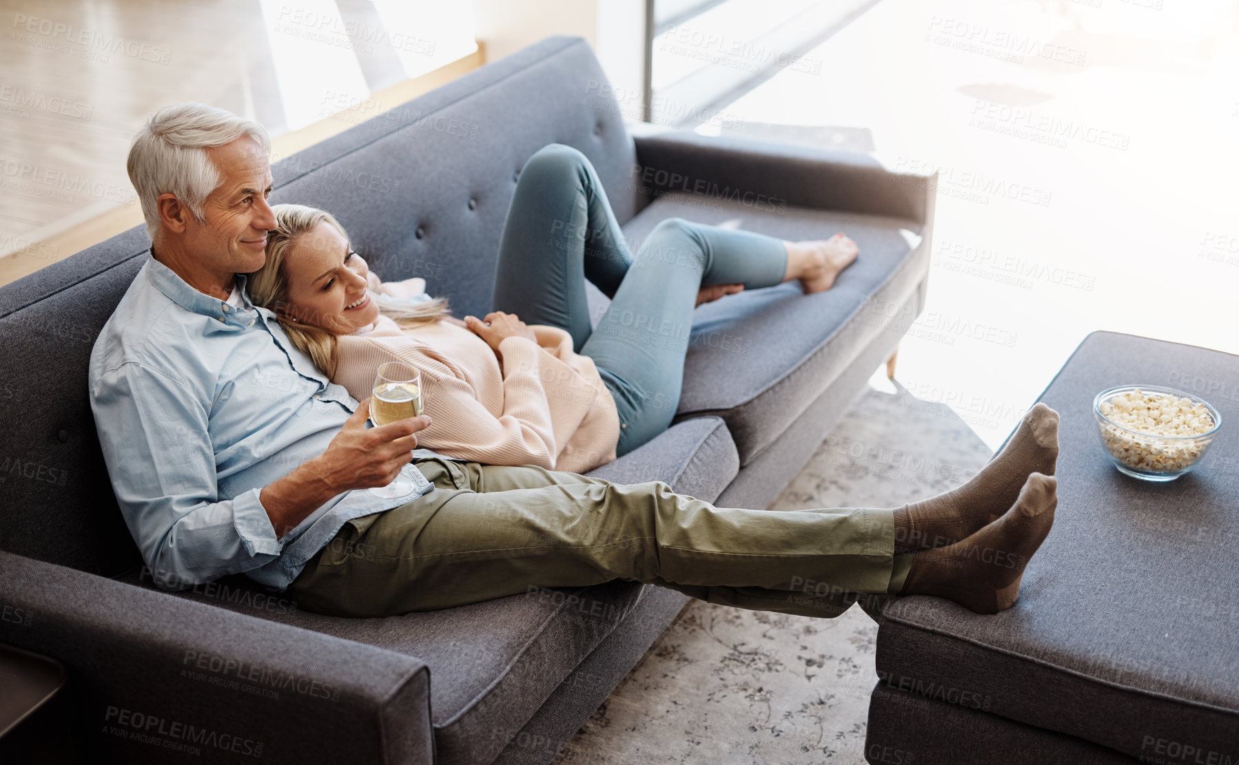 Buy stock photo Watching tv, home and happy couple with movie, series and film streaming with love and support. News, smile and bonding of mature people together on a living room sofa with food, drink and hug