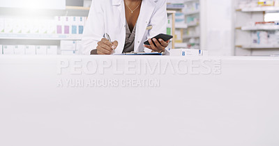 Buy stock photo Cropped shot of an unrecognizable young pharmacist using her cellphone to take notes on a clipboard