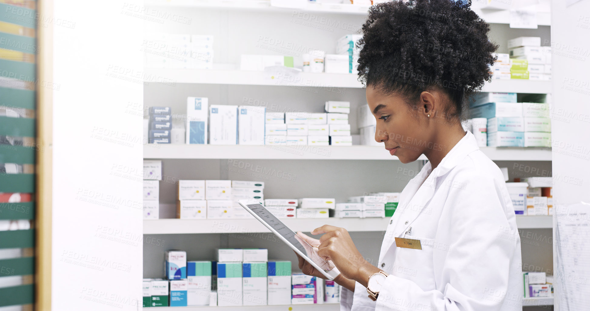 Buy stock photo Cropped shot of an attractive  young pharmacist using a digital tablet in a chemist