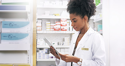 Buy stock photo Cropped shot of an attractive young pharmacist looking at a digital tablet in a chemist