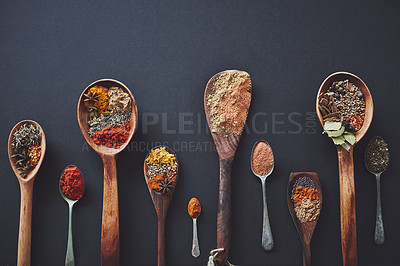 Buy stock photo Table, spoons and group of spices for seasoning, curry and ingredients for flavor on background. Row, top view and collection of herbs or organic turmeric, textures and culinary condiments for food