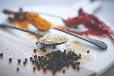 Buy stock photo Board, spices and spoon on table for curry, flavor and sensory appeal for creativity with culinary. Closeup, condiment and seasoning for cooking with powder, aroma or pepper as ingredients collection