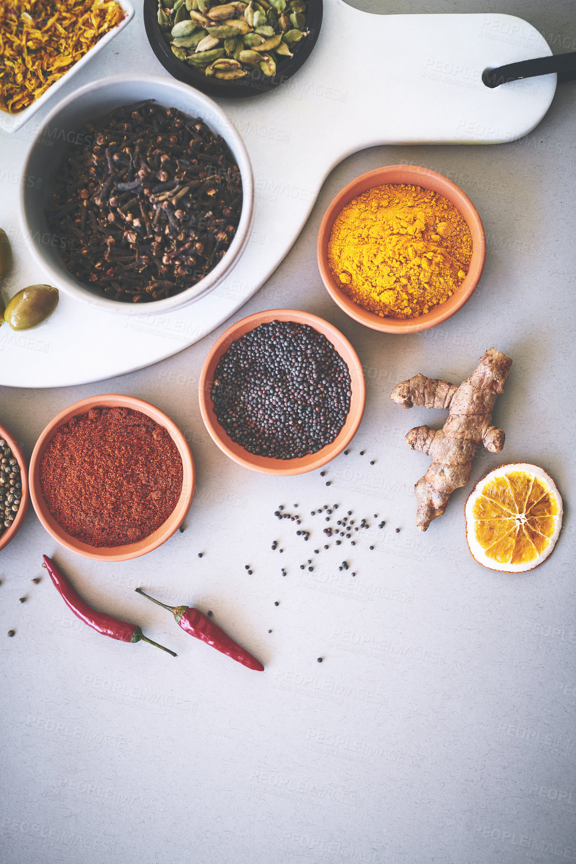 Buy stock photo Bowl, powder and board in white background for spices, curry and sensory appeal for creativity with culinary. Studio, condiment and seasoning for cooking with ginger, aroma and ingredients collection