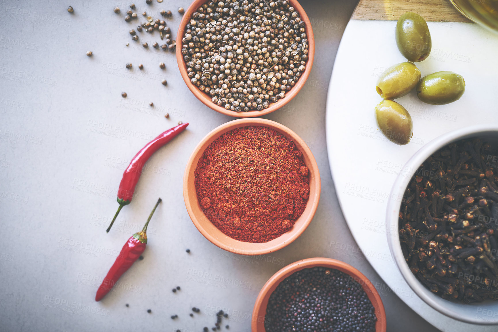 Buy stock photo Bowl, coriander and board in gray background for spices, powder and sensory appeal for creativity with culinary. Studio, condiment and ingredients for cooking with clove, aroma and seasoning by space