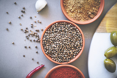 Buy stock photo Above, bowl and board in gray background for spices, powder and variety for sensory appeal with culinary. Studio, condiment or flavor for cooking with ingredients, texture or seasoning collection