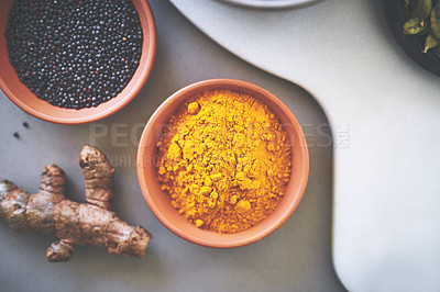 Buy stock photo Above, bowl and turmeric in gray background for spices, powder and variety for sensory appeal with culinary. Studio, condiment and flavor for cooking with ingredients, texture or seasoning collection