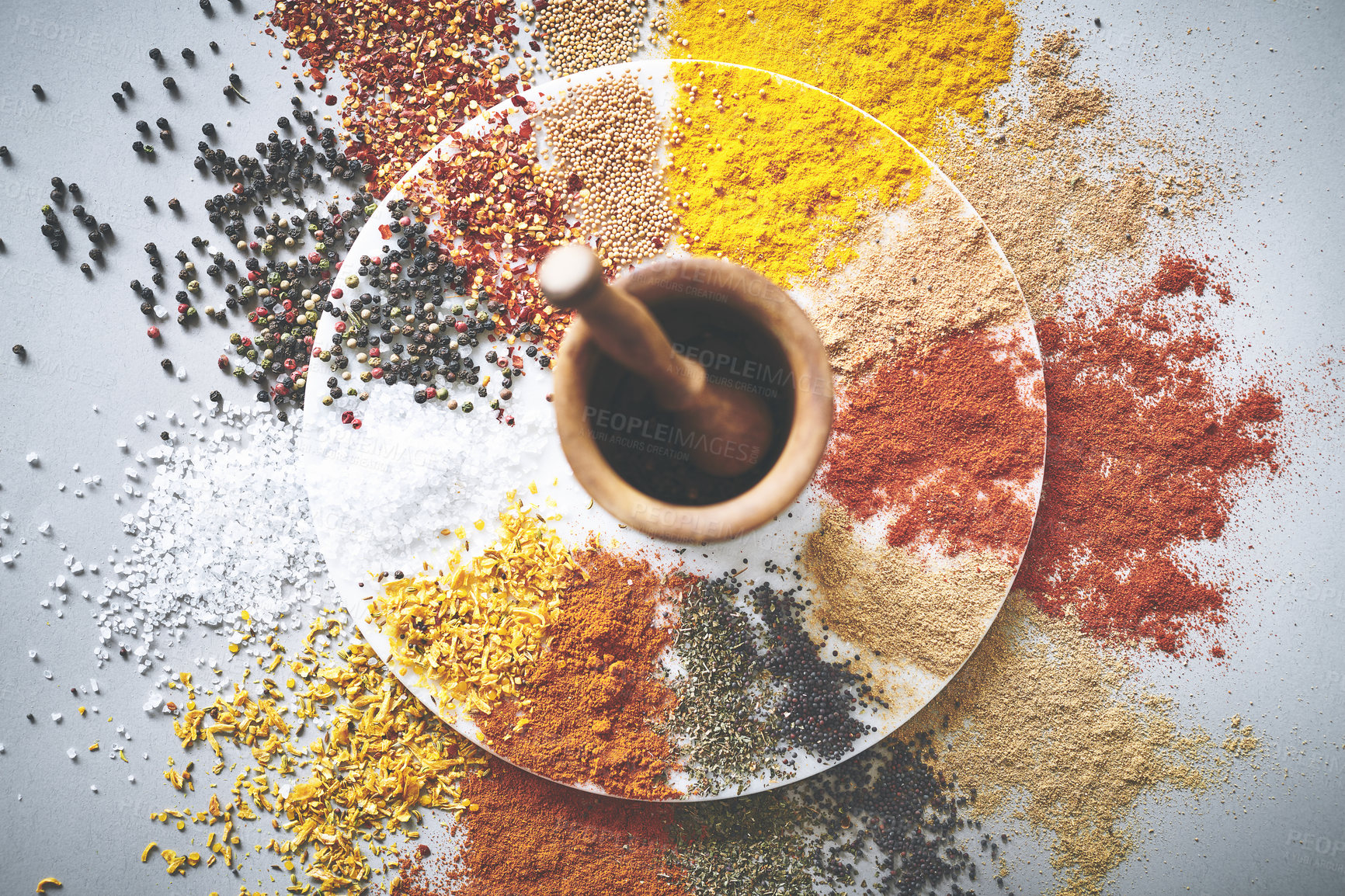 Buy stock photo Mortar, pestle and spices by white background for variety, ingredients and sensory appeal for creativity. Studio, powder and seasoning for cooking with curry, condiment and herbs flavor for culinary