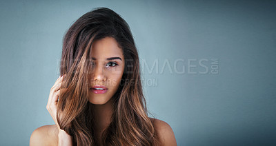 Buy stock photo Studio portrait of a beautiful young woman posing against a gray background