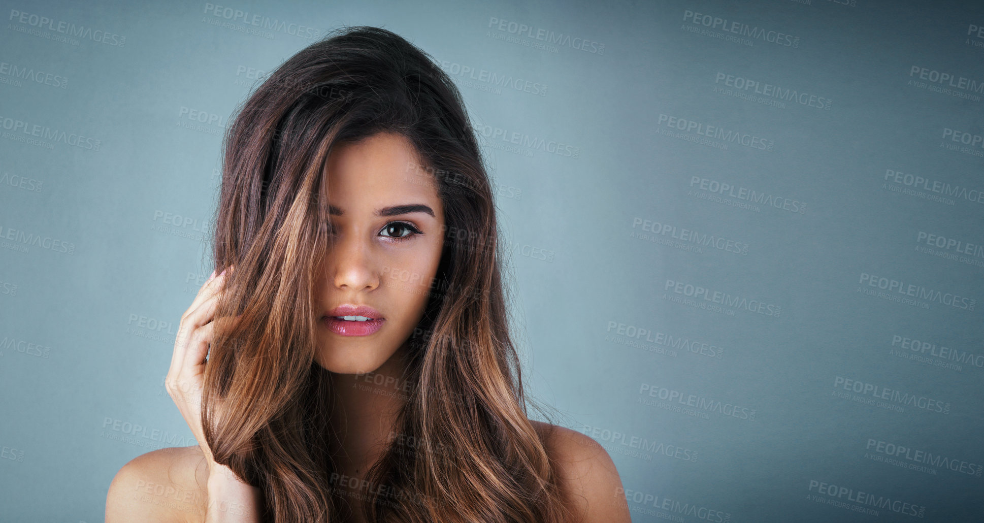 Buy stock photo Studio portrait of a beautiful young woman posing against a gray background