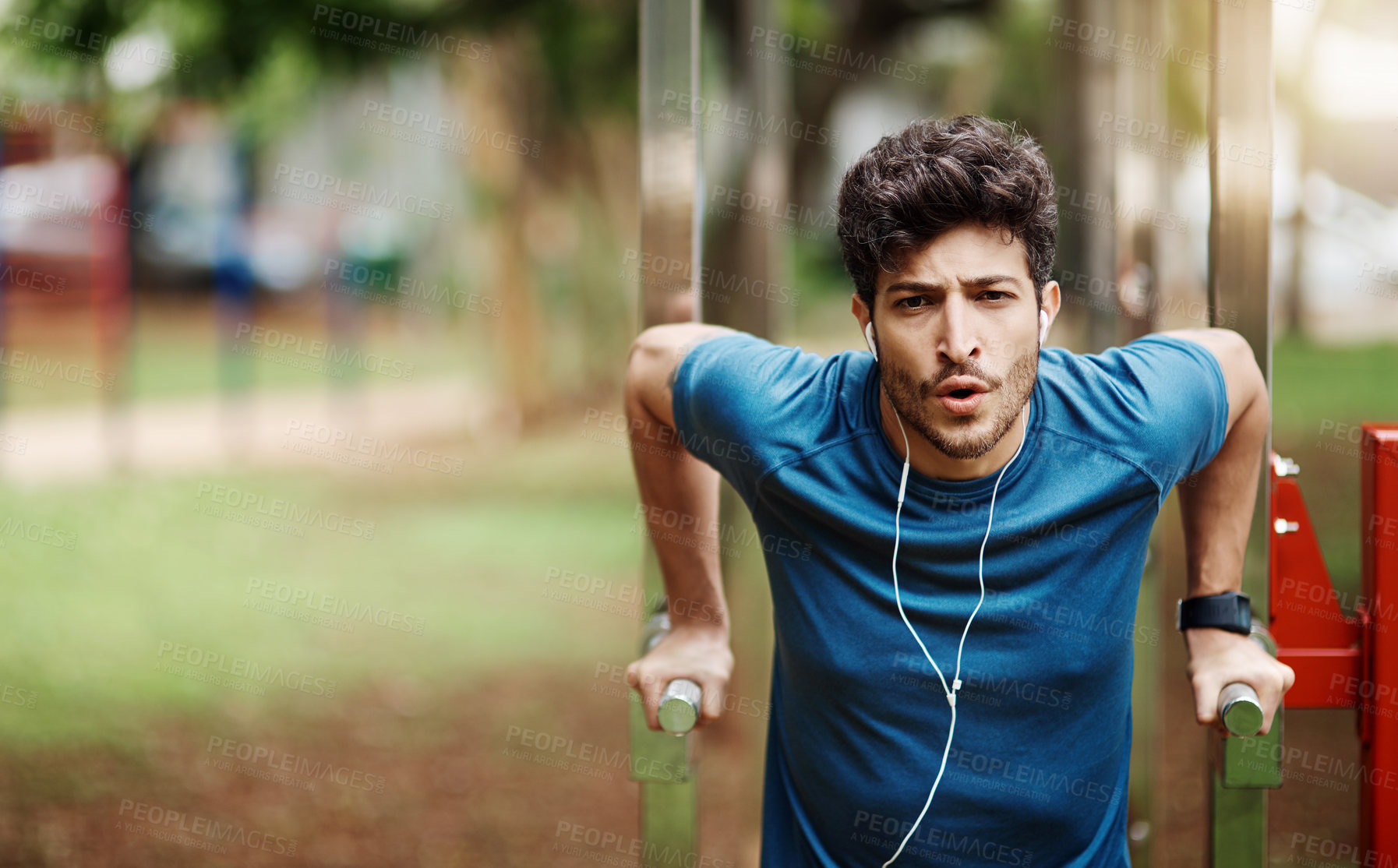 Buy stock photo Portrait of a sporty young man doing stretching techniques while exercising outdoors