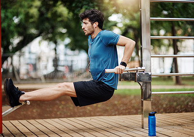 Buy stock photo Shot of a sporty young man doing stretching techniques while exercising outdoors