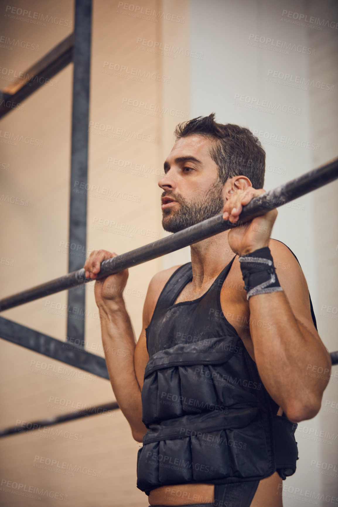 Buy stock photo Cropped shot of a handsome young man doing pulls while working out in the gym