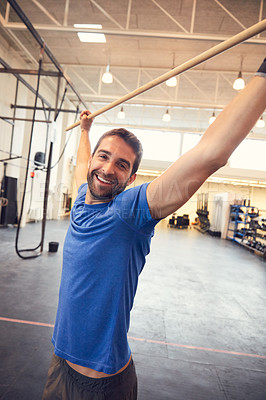 Buy stock photo Cropped portrait of a handsome young man working out in the gym