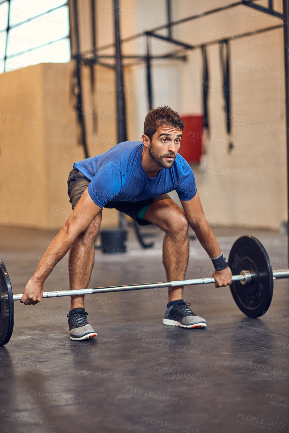 Buy stock photo Full length shot of a handsome young man lifting weights while working out in the gym