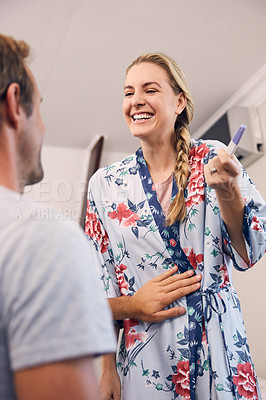 Buy stock photo Shot of a beautiful young couple feeling cheerful after taking a home pregnancy test