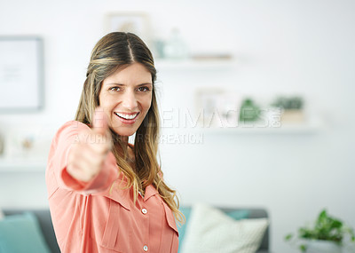 Buy stock photo Cropped shot of a woman showing thumps up while relaxing at home