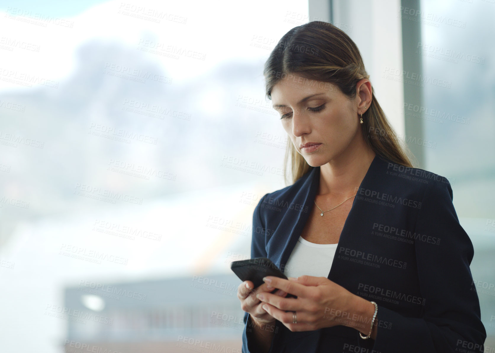 Buy stock photo Cropped shot of a businesswoman using her cellphone at the office