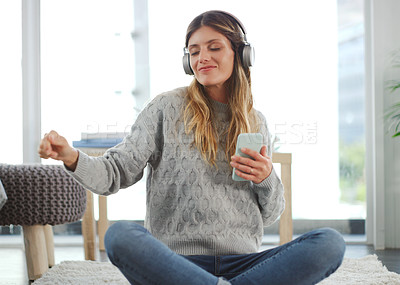 Buy stock photo Shot of an attractive woman using her cellphone while relaxing at home