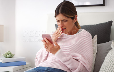 Buy stock photo Shot of a woman looking shocked while reading something on her cellphone