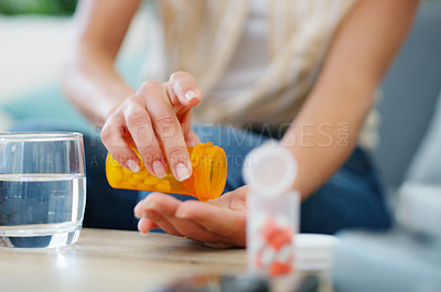Buy stock photo Cropped shot of a woman taking medication at home
