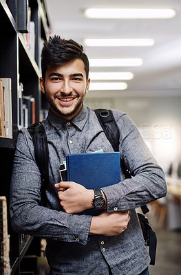 Buy stock photo Portrait of a happy young man carrying books in a library at college