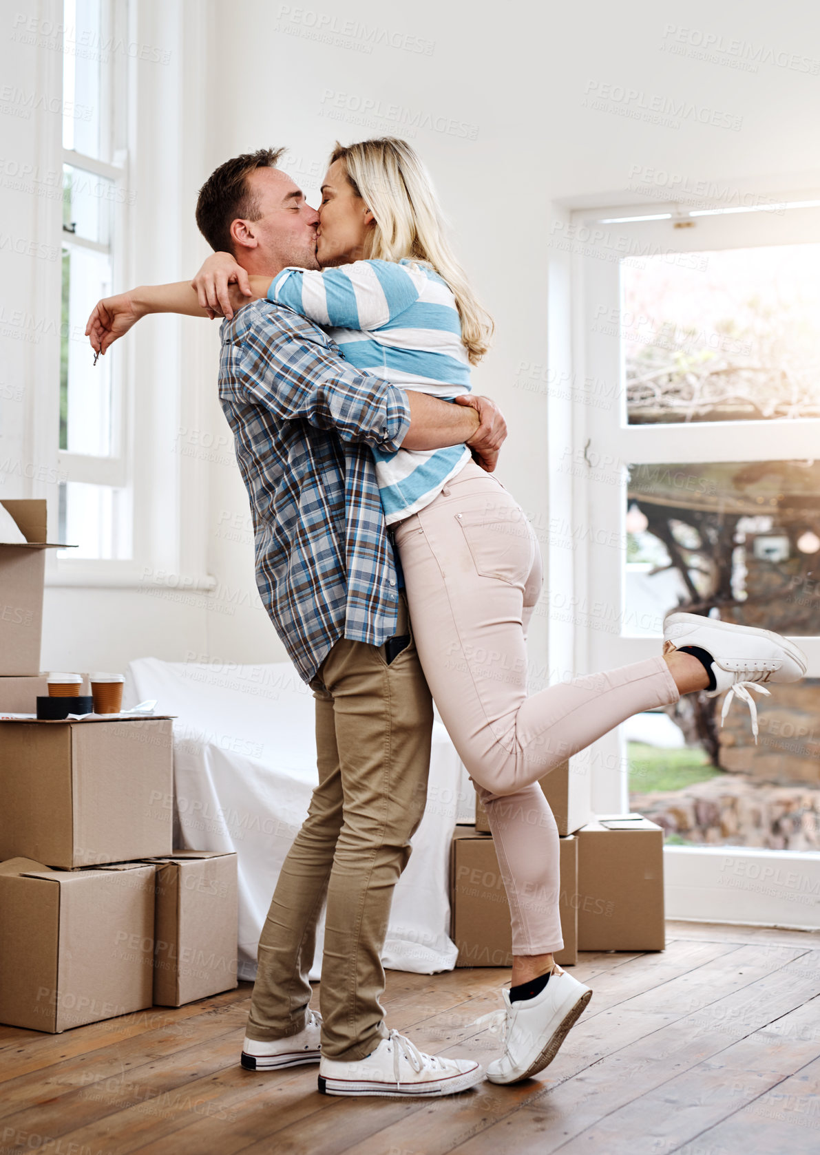 Buy stock photo Portrait, couple and kiss for home, box and man in living room, happy and mortgage for real estate in apartment. Woman, new house and moving with packages, investment and hug for property in USA