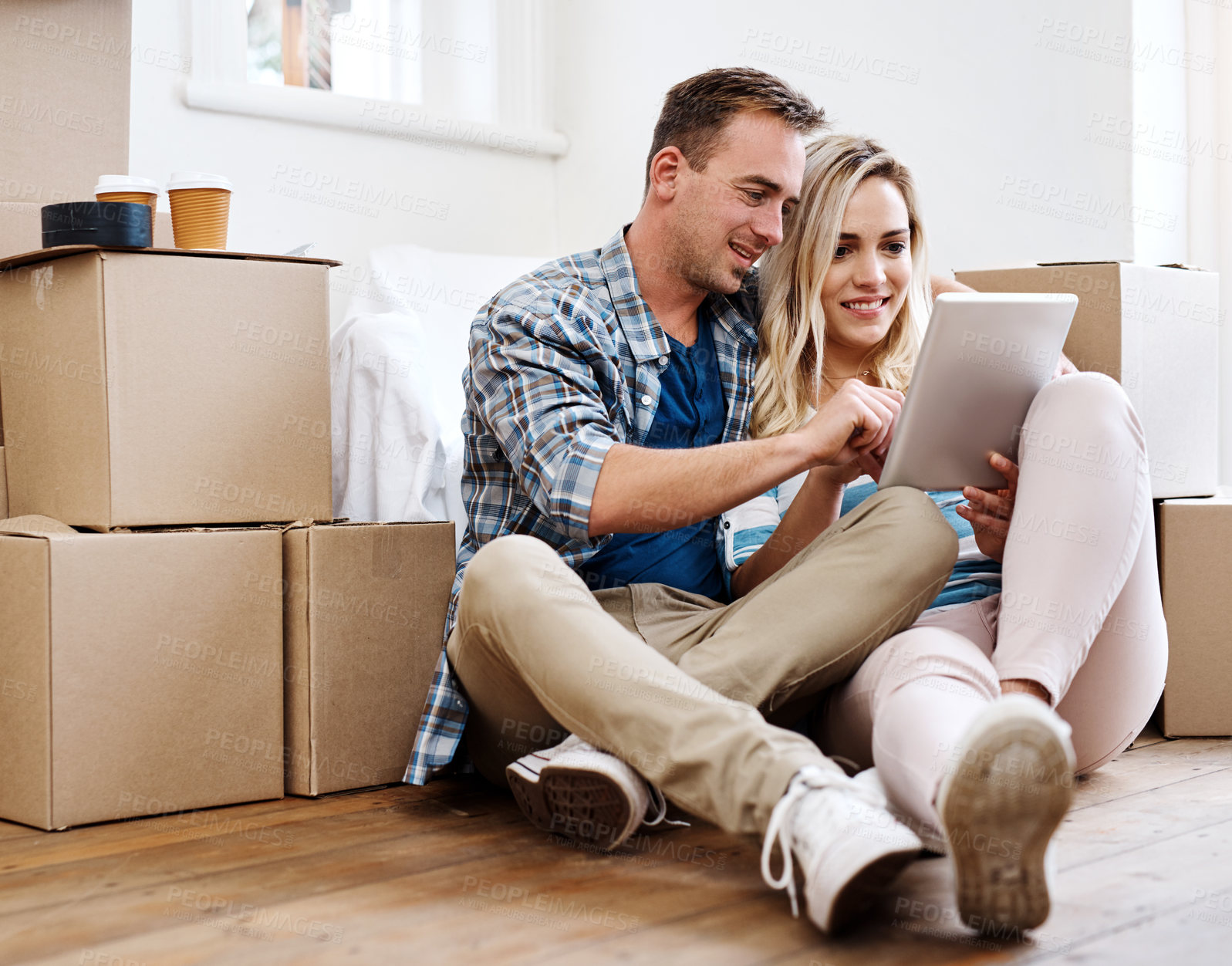 Buy stock photo New home, happy and couple on floor with tablet for property, mortgage purchase and boxes in house. Homeowner, real estate and man and woman on digital tech for interior design, planning or website