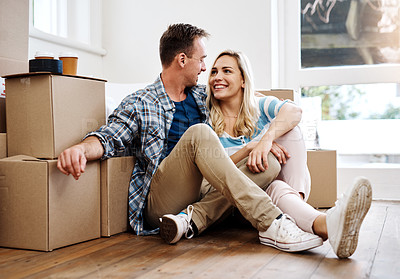 Buy stock photo Shot of a young couple taking a break while moving house