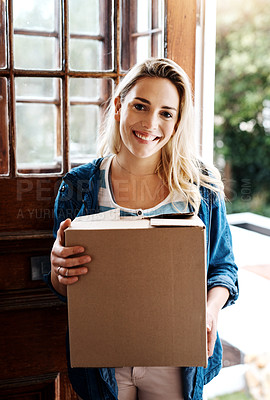 Buy stock photo Portrait of a young woman holding a box while moving house