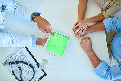 Buy stock photo High angle shot of an unrecognizable doctor using a digital tablet while consulting a couple in his office