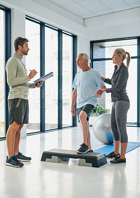 Buy stock photo Full  length shot of two friendly physiotherapists working with a senior patient