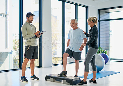 Buy stock photo Full length shot of two friendly physiotherapists working with a senior patient