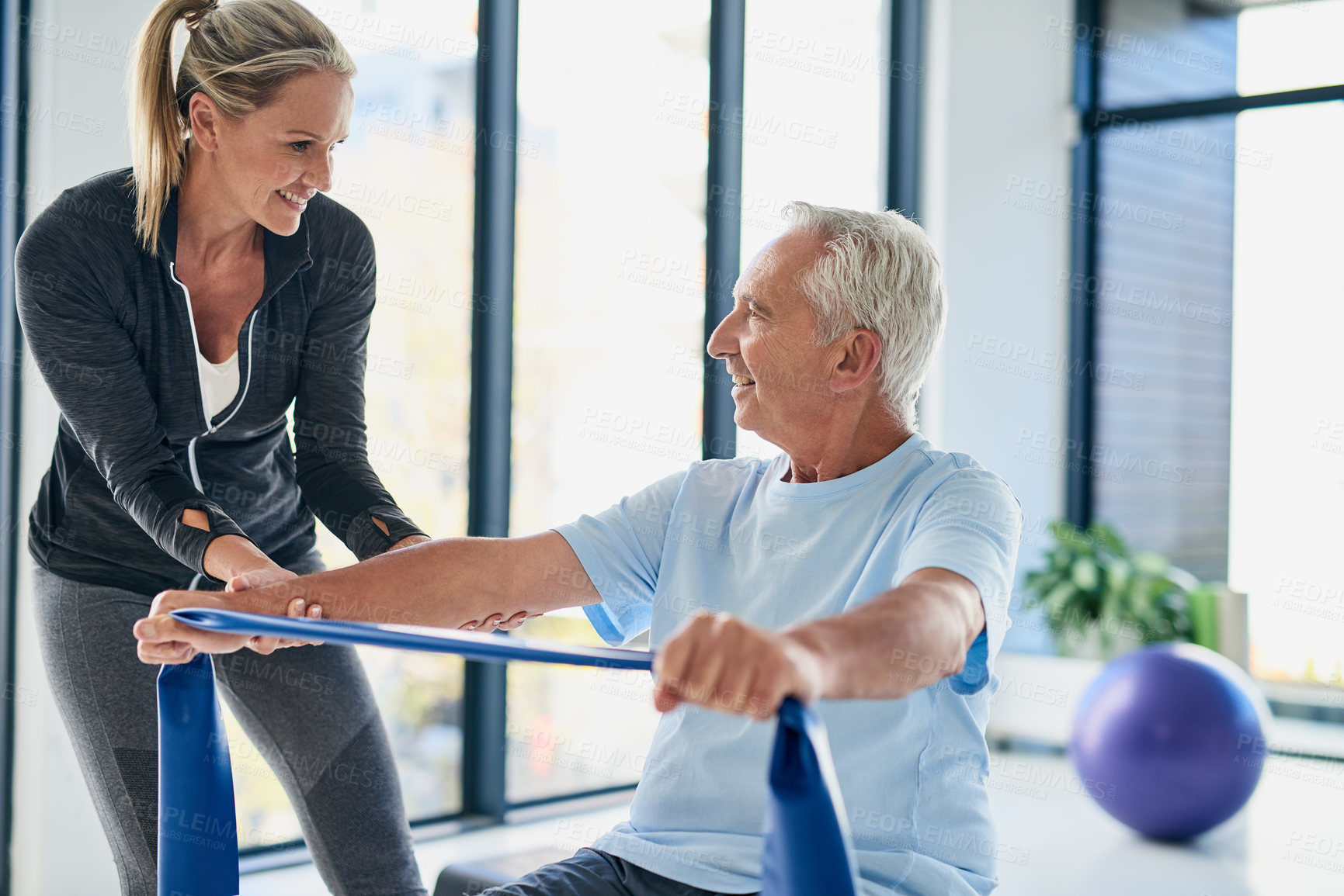 Buy stock photo Fitness, old man and physiotherapist with band for stretching, rehabilitation and healing for injury. Wellness, senior patient and female person with help for physiotherapy, arms recovery or exercise