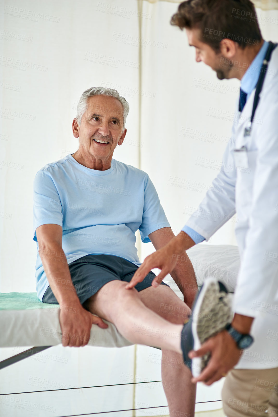 Buy stock photo Cropped shot of a happy senior man attending a knee check up with a doctor