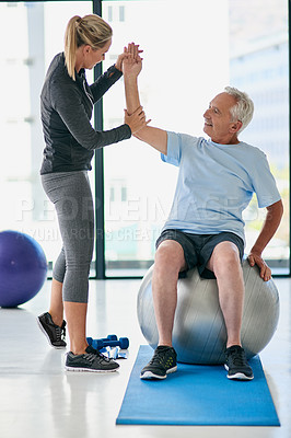 Buy stock photo Full length shot of a friendly physiotherapist helping her senior patient stretch in a fitness centre