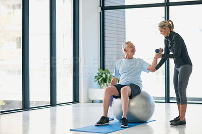 Buy stock photo Full length shot of a friendly female physiotherapist helping her senior patient work out with weights