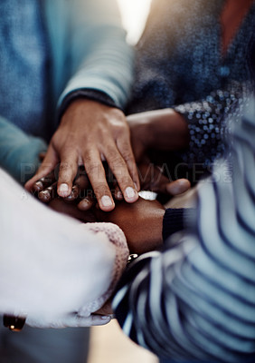 Buy stock photo Closeup shot of a group of university students joining their hands to form a huddle together in unity