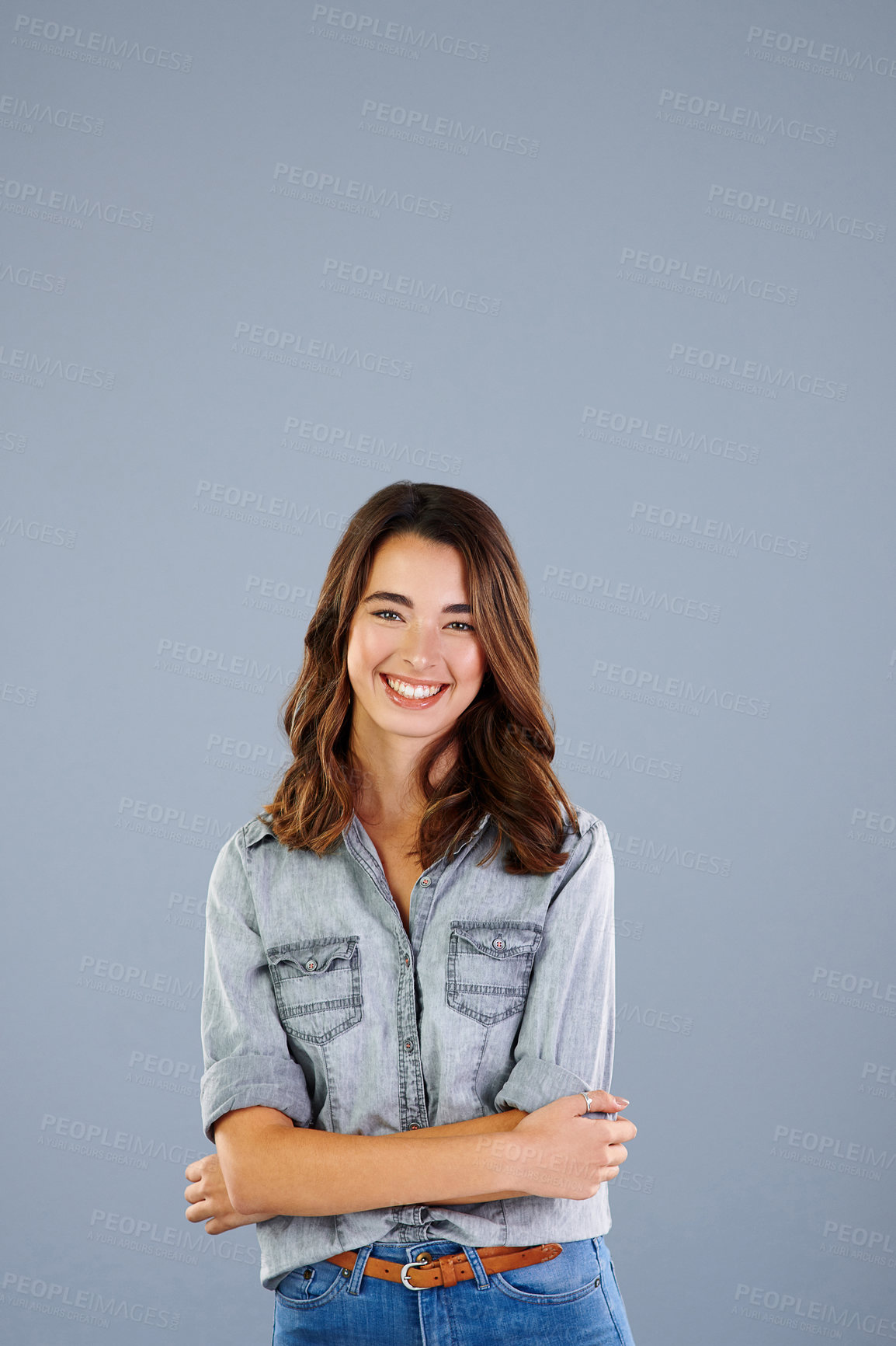 Buy stock photo Studio portrait of an attractive young woman standing with her arms crossed against a grey background